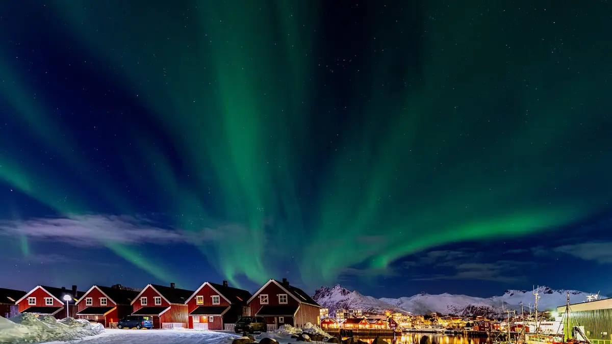 Northern lights over red cabins near Svolvær